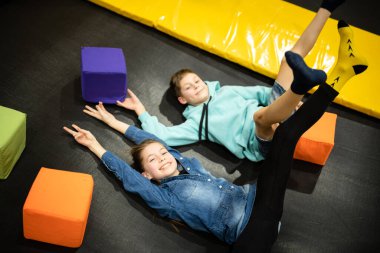 Eğlence merkezinde trambolinde zıplayan 11 yaşındaki mutlu çocuklar. Aktif çocuk eğlencesi, spor merkezinde trambolinde zıplamak ve oynamak. Eğlence parkı. Spor etkinliği.