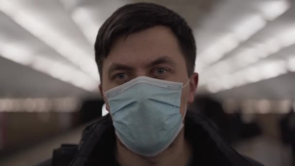 Un hombre de cerca con máscara Covid-19 mirando a la cámara. Estación de metro. Virus Corona. Subte, hombre con máscara médica está triste y molesto, epidemia de coronavirus. Gripe pandémica. Salud. Filtro de aire para smog — Vídeo de stock