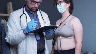 Kalp hastalıkları tedavisi. Sağlık kontrolü. Kardiyolog muayene kardiyolojisi genç bayan hasta, portatif günlük elektrokardiyogram, holter monitör testi kullanın. EKG Elektrotları