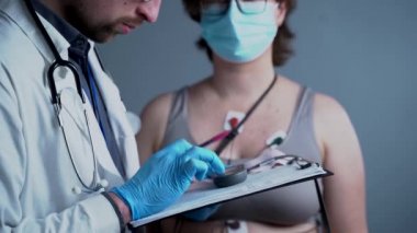 Kardiyolog tıbbi muayene için pano kullanır. Kalp ritmini kontrol etmek için Holter monitörüne bağlanmak üzere göğüs röntgeninde EKG elektrotları var. 24 saatlik tutucu elektrokardiyografiyi izliyor