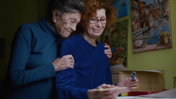 Couple âgé 90 ans maman et fille aînée câlin et peinture. Retraite, apprendre de nouveaux passe-temps peindre des images avec pinceau ensemble à la maison en quarantaine. Passer du bon temps avec une mère célibataire — Video