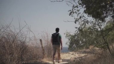 Kafkas erkek turist güneşli yaz havasında dağ yolunda haikin yaparken deniz manzarası seyrediyor. Lycian yolunda yürüyüş. Sırt çantalı gezgin uçurumun kenarında duruyor. Macera, seyahat insanları konsepti
