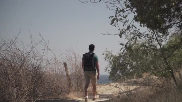 Caucasian male tourist delighting sea view in sunny summer weather during haikin on mountain trail. Hiking on Lycian way. Traveler with backpack stands on cliff. Adventure, travel people concept — Stock Video