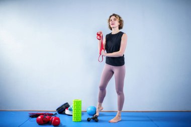 Sporcu kadın direniş bandıyla egzersiz yapıyor. Millet, spor ve spor. Spor salonunda spor grubuyla antrenman yapan genç bir kadın. Aktif yaşam tarzı. Lastik bant ile antrenman. Lastik genişletici.