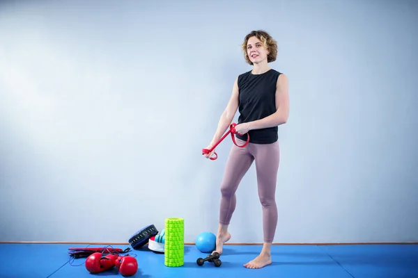 Sporty woman exercising with resistance elastic bands at gym. Athlete lady doing workout with elastic band. People, sport, fitness concept. Strength and vitality. Using resistance band for exercising.