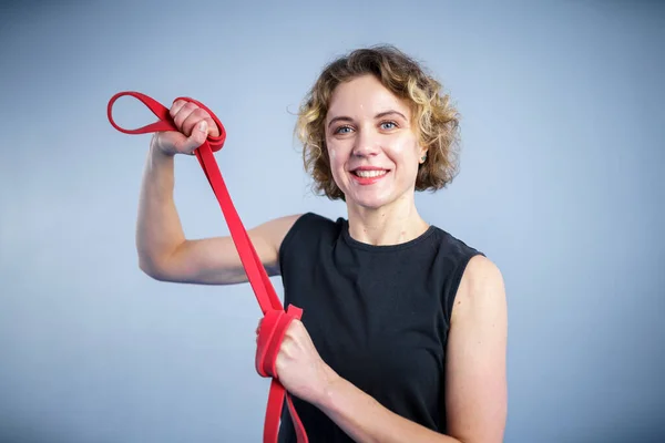 Sporty woman exercising with resistance elastic bands at gym. Athlete lady doing workout with elastic band. People, sport, fitness concept. Strength and vitality. Using resistance band for exercising.