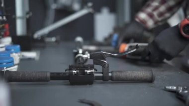 Çevre dostu elektrikli araç tamir servisi. Beyaz erkek elektrikli taşıma tamircisi istasyonda çalışıyor. Tamir ve hizmet için atölyede çalışan adam, elektrik itme scooterını tamir ediyor.