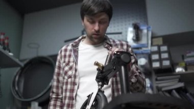 Erkek makine mühendisi, tamirci çocuk scooterındaki mekanik hasarı tamir ediyor. Mobiletlerin ekolojik taşımacılığında hizmet ve bakım için küçük bir işletme. Kırık tekme e scooter