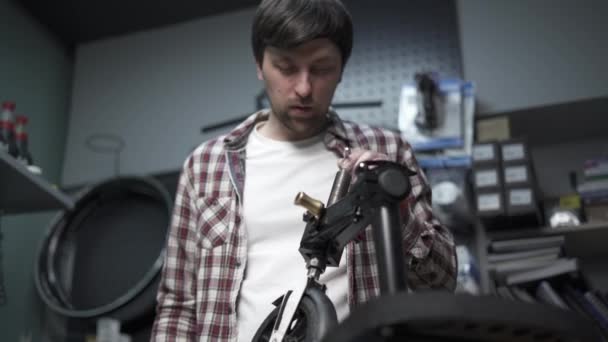 Erkek makine mühendisi, tamirci çocuk scooterındaki mekanik hasarı tamir ediyor. Mobiletlerin ekolojik taşımacılığında hizmet ve bakım için küçük bir işletme. Kırık tekme e scooter — Stok video