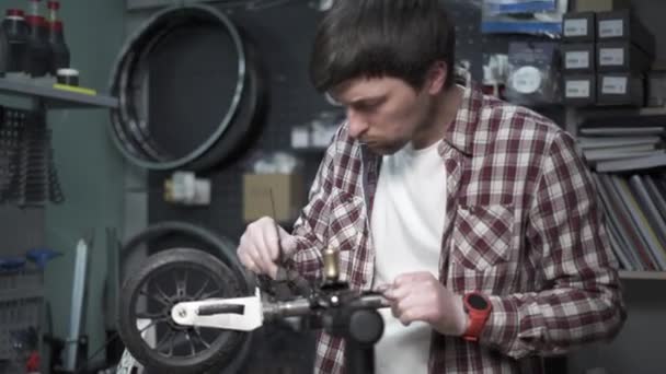 男机械工程师、修理工修理儿童滑板车轮子的机械损坏.小企业服务和维护摩托车的生态交通.断腿和滑板车 — 图库视频影像