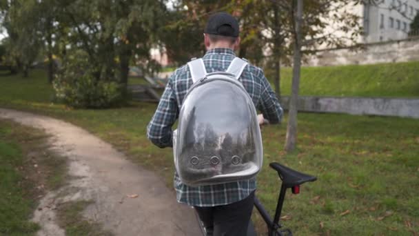 Toujours voyager animal de compagnie et propriétaire ensemble. Cycliste porte jeune chat gris dans un sac à dos spécial pour animaux de compagnie avec fenêtre et ventilation à vélo. Randonnée VTT à thème avec chat dans un sac à dos — Video