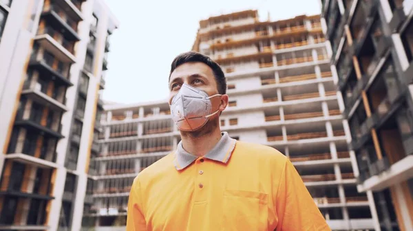 Güvenlik ekipmanı takan inşaat işçisi. KN 95 maskesi. Corona maskesi. Covid-19 koruyucu solunum cihazı. Coronavirüs salgını. İnşaatçı koruyucu ekipman solunum cihazında çalışıyor..