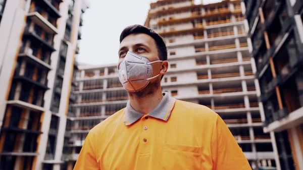 Güvenlik ekipmanı takan inşaat işçisi. KN 95 maskesi. Corona maskesi. Covid-19 koruyucu solunum cihazı. Coronavirüs salgını. İnşaatçı koruyucu ekipman solunum cihazında çalışıyor..