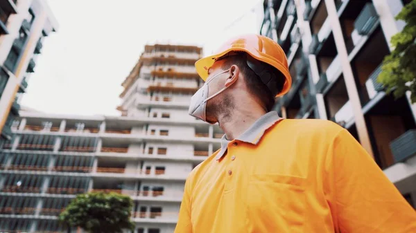 Güvenlik ekipmanı takan inşaat işçisi. KN 95 maskesi. Corona maskesi. Covid-19 koruyucu solunum cihazı. Coronavirüs salgını. İnşaatçı koruyucu ekipman solunum cihazında çalışıyor..