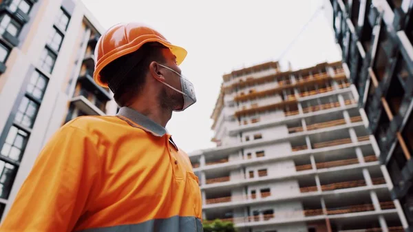 Güvenlik ekipmanı takan inşaat işçisi. KN 95 maskesi. Corona maskesi. Covid-19 koruyucu solunum cihazı. Coronavirüs salgını. İnşaatçı koruyucu ekipman solunum cihazında çalışıyor..