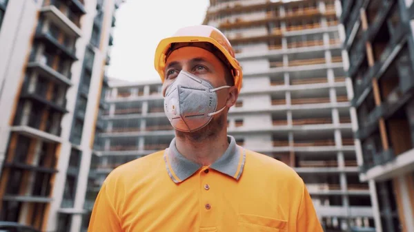 Güvenlik ekipmanı takan inşaat işçisi. KN 95 maskesi. Corona maskesi. Covid-19 koruyucu solunum cihazı. Coronavirüs salgını. İnşaatçı koruyucu ekipman solunum cihazında çalışıyor..