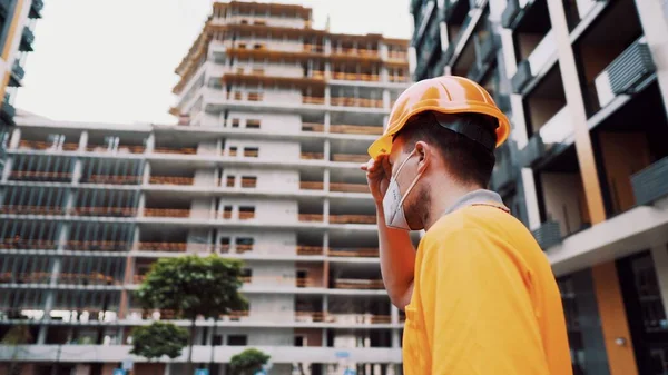 Güvenlik ekipmanı takan inşaat işçisi. KN 95 maskesi. Corona maskesi. Covid-19 koruyucu solunum cihazı. Coronavirüs salgını. İnşaatçı koruyucu ekipman solunum cihazında çalışıyor..
