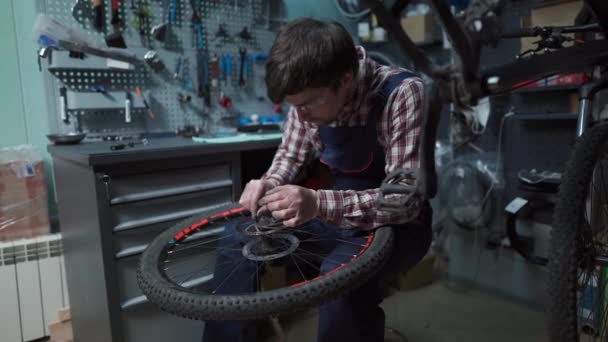 Sklep rowerowy mechanik mocowania koła rowerowego w warsztacie. Naprawa serwisantów, cykl konserwacji. Velocipede naprawy rowerów w sklepie rowerowym. Koncepcja usługi naprawy rowerów. Pojazdy przyjazne dla środowiska — Wideo stockowe