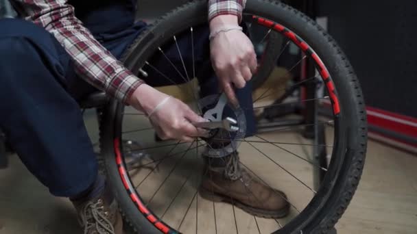 Bike shop mechanic fixing bicycle wheel in workshop. Serviceman repair, maintenance cycle. Velocipede repairing bicycle in bike shop. Bicycle repair service concept. Environmentally friendly vehicles — Stock Video