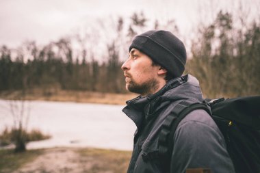 Yalnız, üzgün bir adam, arkası dönük ve donmuş göl ormanlarına bakıyor. Depresyon, kötü ruh hali ve intihara meyilli düşünceler. Psikolojik yardıma ihtiyacım var. Kış doğası ve erkek hayatı düşünür..