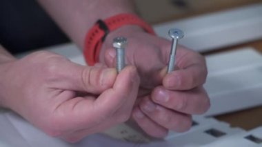 DIY beyaz masa montaj işlemi evde yapılıyor. Mobilya döşemesi. Yeni ev ve mobilya montajı yapan adam bunu kendi başına yapıyor. Kattaki talimatlara göre, kutudan itibaren erkek montaj tablosu