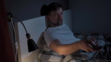 Gece yarısı internet üzerinden televizyon izleyen bir adam. Bağımlı erkek TV izlemek için geç saatlere kadar çalışıyor. Uykusuzluk. Tembellik, sakinlik, televizyon bağımlılığı