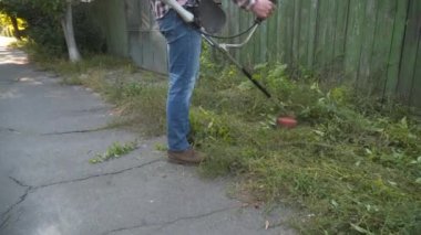 Profesyonel yol kenarı biçimi. Çimleri biçmek için çalı kesen bir kamu görevlisi. Bahçıvan otları biçer. Benzin çim biçme makinesi olan adam. Tulumlu işçiler yol kenarındaki budama makinesiyle çimenleri biçiyor.