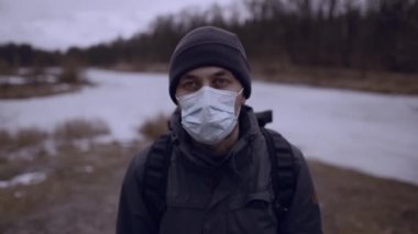 Mutlu adam doğada maskesini çıkarıyor. Erkek, kırsalda, insanlardan uzakta tıbbi maskeyi çıkartıp derin temiz hava soluyor. Yenilen koronavirüs ve covid-19 kavramı