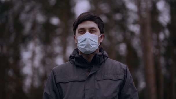 Hombre feliz quitándose la mascarilla en la naturaleza. El macho se quita la máscara médica de su cara en el campo lejos de la gente y respira aire profundamente limpio. Concepto de coronavirus derrotado y covid-19 — Vídeo de stock