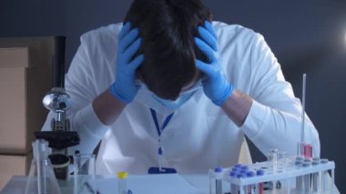 Tıbbi maskeli bitkin bir doktor ve üstünde de koronavirüs yazıyor. Tıbbi sistem çöküyor, sağlık çalışanları bitkin ve çok hasta. Sağlık personeli tıbbı yoruldu