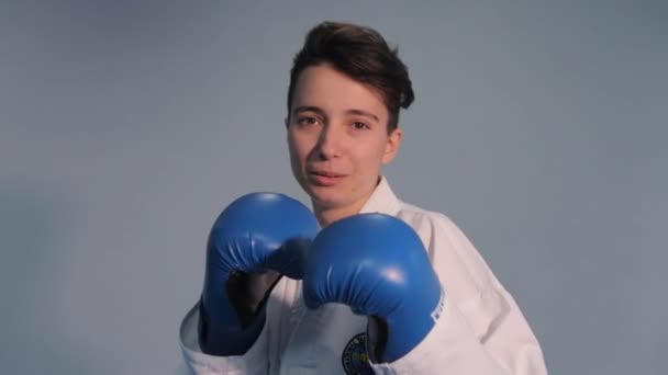 Woman taekwondo fighter trains shadow boxing punches and kicks. Girl wearing in white kimono performing martial arts kick skill. Woman in kimono practicing taekwondo. Ukraine, Kiev March 20, 2017 — Stock Video