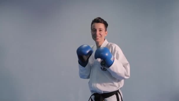 Bojovnice taekwondo trénuje stínové boxerské údery a kopy. Dívka v bílém kimonu předvádějící bojová umění kopat dovednosti. Žena v kimonu cvičí taekwondo. Ukrajina, Kyjev 20. března 2017 — Stock video