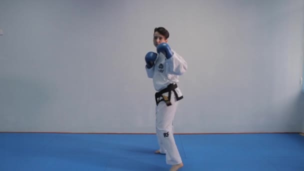 Mulher treinando truques taekwondo no ginásio. quimono branco feminino demonstra técnica de karatê. Conceito de arte marcial. Desportista realiza combinação tradicional de socos. Ucrânia, Kiev 20 de março de 2017 — Vídeo de Stock