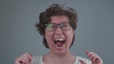 Duygusal çılgın genç kadın gülüyor dişsiz gülümsüyor, saçlarını dalgalandırıyor ve stüdyoda kırışıyor. Komik dişsiz kadın çıldırdı. Akıl sağlığı, endişe, stres konsepti