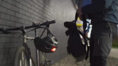 Adam şehirde dolaşmak için bisiklet kullanıyor. Bir bisikletçi gece işten eve gitmeden önce kırmızı ışıklı bir kask giyer. Bisikletli teslimatçı siparişi almak için dışarı çıkar.