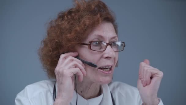 Μεσήλικες γυναίκες παθολόγος έχουν βιντεοκλήση με συναδέλφους στο γραφείο. Γιατρός μιλάει με ασθενή κατά τη διάρκεια εικονικής ιατρικής ραντεβού. Ομιλία ιατρού από online βιντεοκλήση webcam στο laptop — Αρχείο Βίντεο