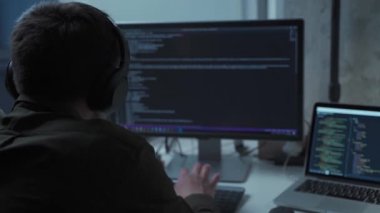 Kulaklık programcısı, bilgisayar ve dizüstü bilgisayarın arkasında yeni yazılım geliştirme çalışmaları ile gürültüyü iptal ediyor. Ofisteki bilgisayarda çalışan uygulama geliştiricisi. Evden çalışma, uzaktan çalışma konsepti