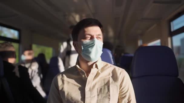 電車の中でcovid-19ロックダウン中に顔マスクを身に着けている男性乗客。新しい通常のライフスタイルコンセプト。公共交通機関で移動するときの社会的距離。コロナウイルスのパンデミックの間の通信 — ストック動画