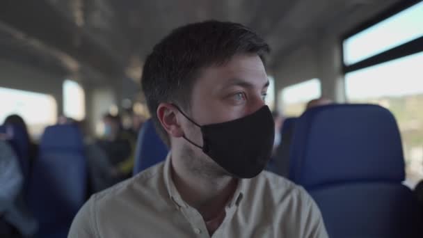 Passageiro do sexo masculino usando máscara facial durante o bloqueio do covid-19 dentro do trem. Novo conceito de estilo de vida normal. Distanciamento social ao viajar de transportes públicos. Comutação durante a pandemia de coronavírus — Vídeo de Stock