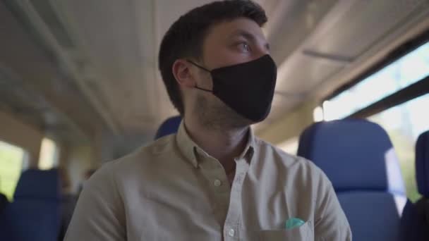 公共交通機関で安全に19をcovid旅行します。保護マスクを持つ列車の乗客は、新しい規範、鉄道運送の社会的距離と席に座って旅します。コロナウイルスのパンデミックの間の旅行 — ストック動画