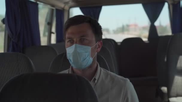 Einsamer Mann mit Schutzmaske reist in einem traditionellen alten Kleinbus durch Zypern während der Quarantäne, neue Regeln des Coronavirus. Männliche Touristen reisen mit 19 Jahren in einem leeren Bus in der Stadt Paphos — Stockvideo