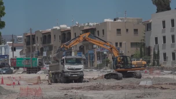 11 de mayo de 2021 Chipre, Paphos. Maquinaria de construcción durante los trabajos de reparación de carreteras en el sitio de construcción cerca del puerto en la ciudad de Paphos. Trabajos de construcción de carreteras. Sitio de construcción contra edificios en el centro — Vídeo de stock