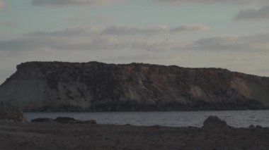 Agios Georgios Kıbrıs 'ın Rocky kıyısında. Yeronisos adasının manzarası. Kıbrıs 'ın Paphos kentindeki Agios Georgios Pegeias limanında gün batımı. Akamas Yarımadası ve Geronisos Adası