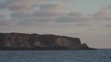 Agios Georgios Kıbrıs 'ın Rocky kıyısında. Yeronisos adasının manzarası. Kıbrıs 'ın Paphos kentindeki Agios Georgios Pegeias limanında gün batımı. Akamas Yarımadası ve Geronisos Adası