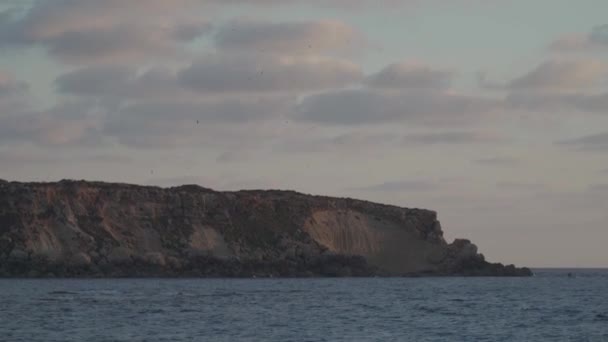 Skalnatý břeh Agios Georgios Cyprus. Pohled na ostrov Yeronisos. Západ slunce v přístavu Agios Georgios Pegeias v Paphos na Kypru. Poloostrov Akamas a ostrov Geronisos — Stock video