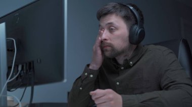 Genç beyaz adam bilgisayar başında fazla mesai yapıyor ve ofisteki monitörden dolayı göz yorgunluğu çekiyor. Erkek, bilgisayar üzerinde çalışırken stresli zaman geçiriyor. Yorgun programcı stresli iş, iş yerinde stres.