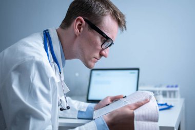 Kalp hastalıklarına zamanında bakmanın konusu. Kalp hastalığı miyokardiyal enfarktüs. Hastane ofisindeki masada elektrokardiyogramı analiz eden doktor. Klinikte kardiyolog. Doktor EKG 'ye bak..