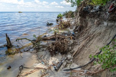 Garbage on coastline Dnieper river in Ukraine near Kiev. Contamination of environment by humans. People left trash on river bank. Ecological disaster of water resources. Trash washed up on a beach