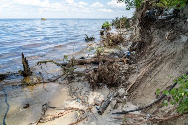 Environmental problem caused by human activity. Trash tourism. Pollution of Kiev Sea in Ukraine. Plastic garbage on shore of pond. Rubbish and waste left by bad people after vacation on dnieper river