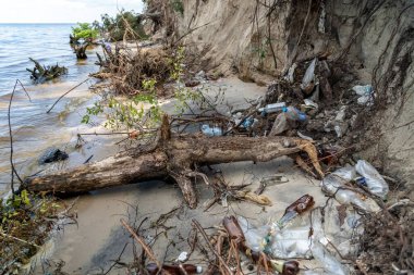 Environmental problem caused by human activity. Trash tourism. Pollution of Kiev Sea in Ukraine. Plastic garbage on shore of pond. Rubbish and waste left by bad people after vacation on dnieper river